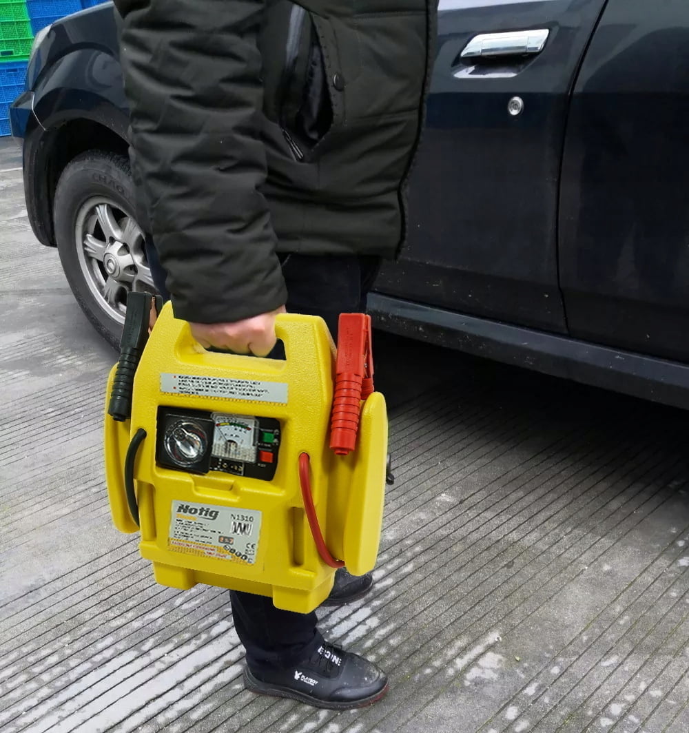4v1 LED 12V booster 900A zaganjalec Jump Starter polnilec in kompresor 17 a person holding a yellow box with a red and black battery